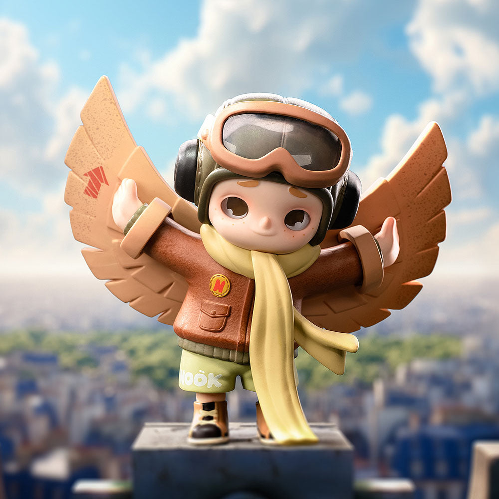 Toy figure with wings and goggles against a cityscape background