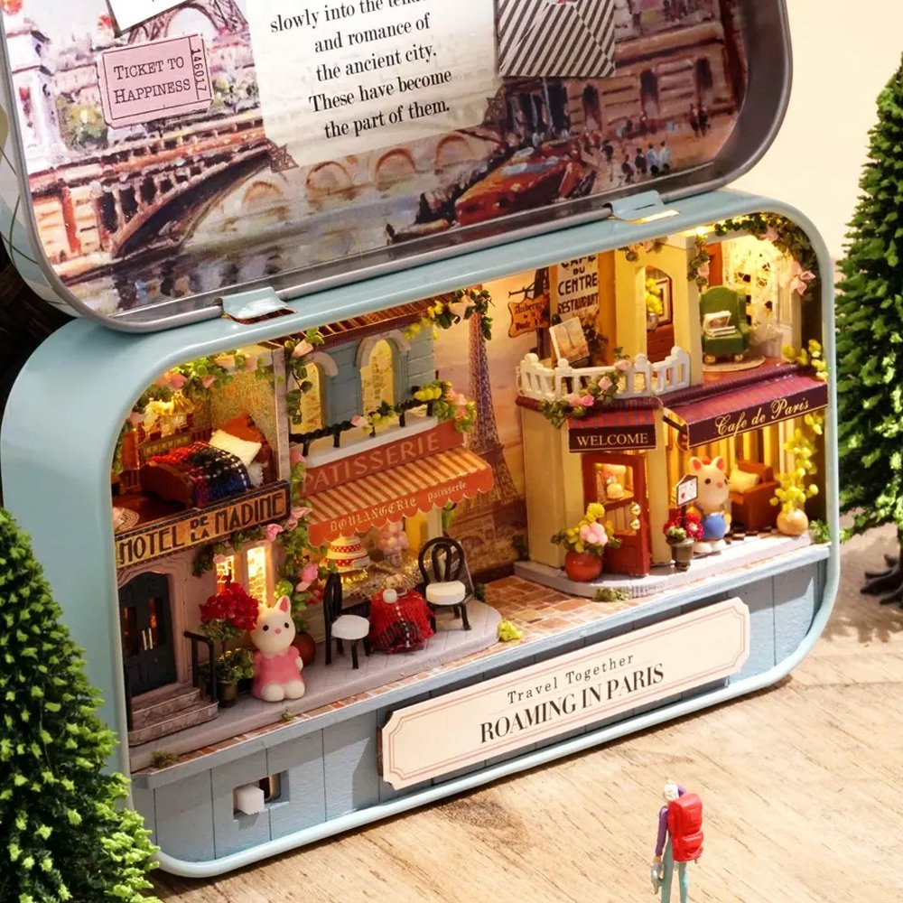 A intricate DIY miniature kit replicating a traditional Parisian cafe with a European designed facade, outdoor seating, and warm LED light