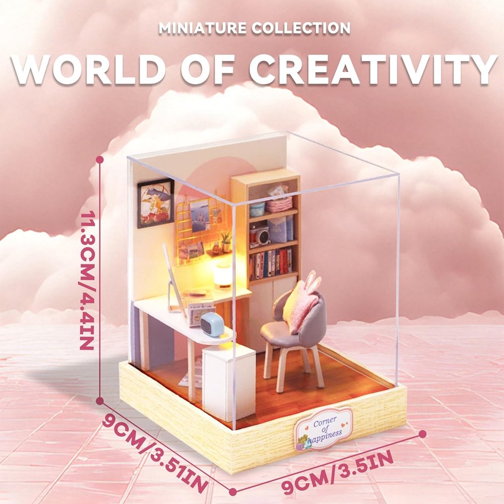 A cozy DIY miniature study room featuring a white desk with a computer, a bookshelf, and a gray chair with a pink bunny-ear cushion