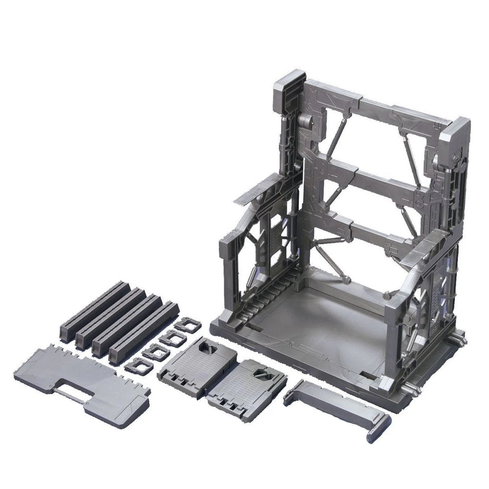 An officially licensed Bandai System Base 001 model kit display stand in metallic gunmetal gray. The retail packaging shows the mechanical hangar holding 1/144 scale Gunpla figures, highlighting its adjustable structural parts and industrial detail.