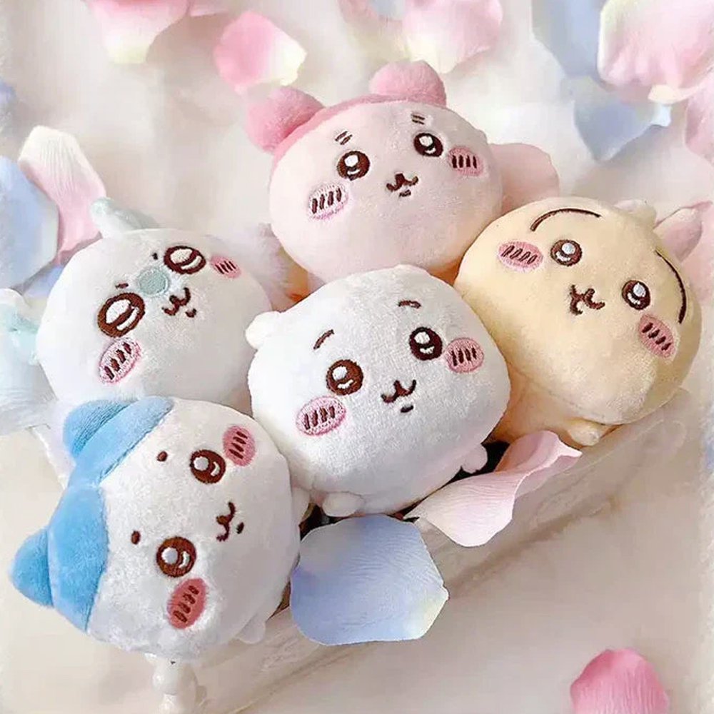 An collection of five officially licensed Chiikawa "nesoberi" laying-down plush toys, featuring the characters Chiikawa, Hachiware, Usagi, Momonga, and Kani against a green polka-dot background. The plushies are small, rounded, and white, blue, yellow, and pink in color with sweet embroidered faces.