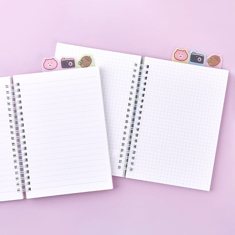 Officially licensed Chiikawa spiral notebooks with index tabs, featuring Chiikawa studying on a pink cover, while the other shows the trio on a yellow and blue background; both include built-in tabs shaped like a bear, a camera, and an acorn.