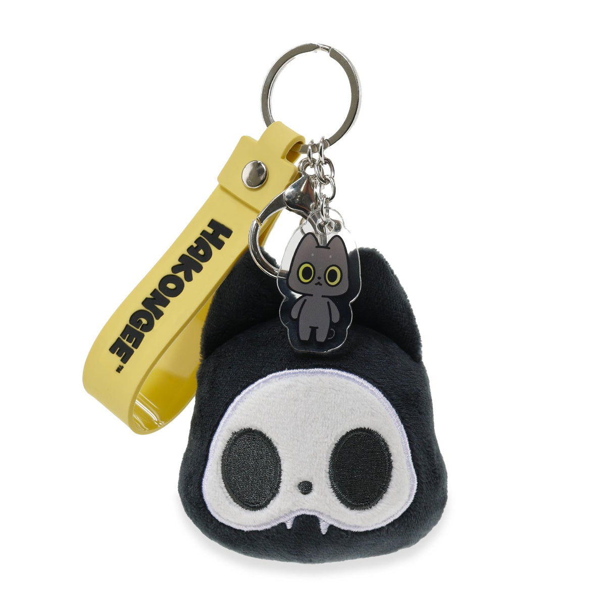 Black skull-shaped plush keychain with a yellow tag and black cat charm on a white background