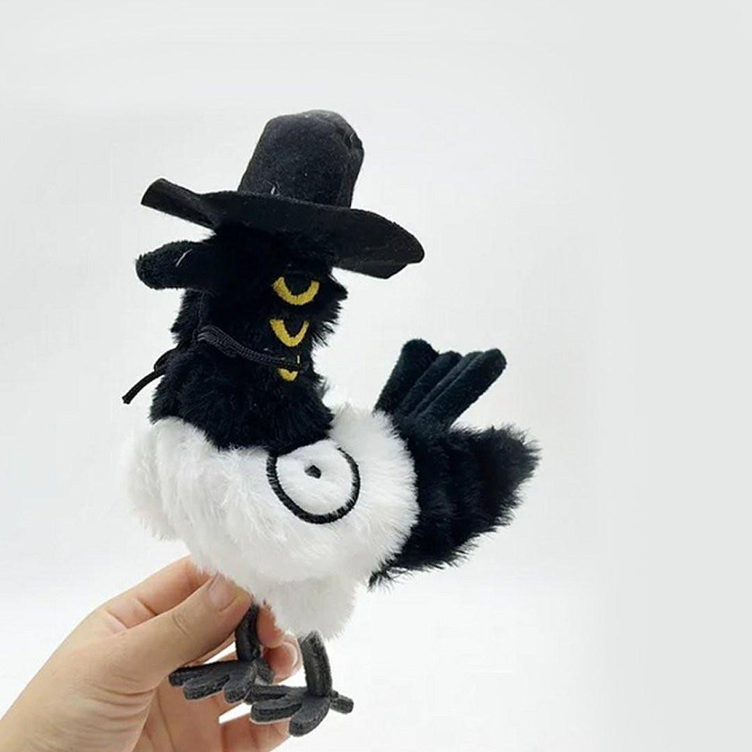 A person holding the K-Pop Demon Hunters Sussie Plush toy. The bird of magpie with a Korean traditional gat hat held by a hand on a white background