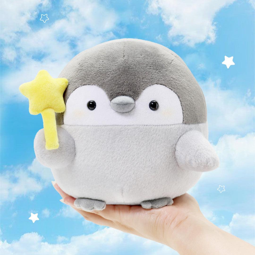 Official Spiralcute Koupen Chan Star Wand Plush held in hand; featuring the positive penguin with a yellow star wand against a dreamy blue sky background. A premium nostalgic aesthetic for adult mental wellness, perfect for graduation gifts, "get well soon" surprises, and office-core healing decor for dedicated collectors.