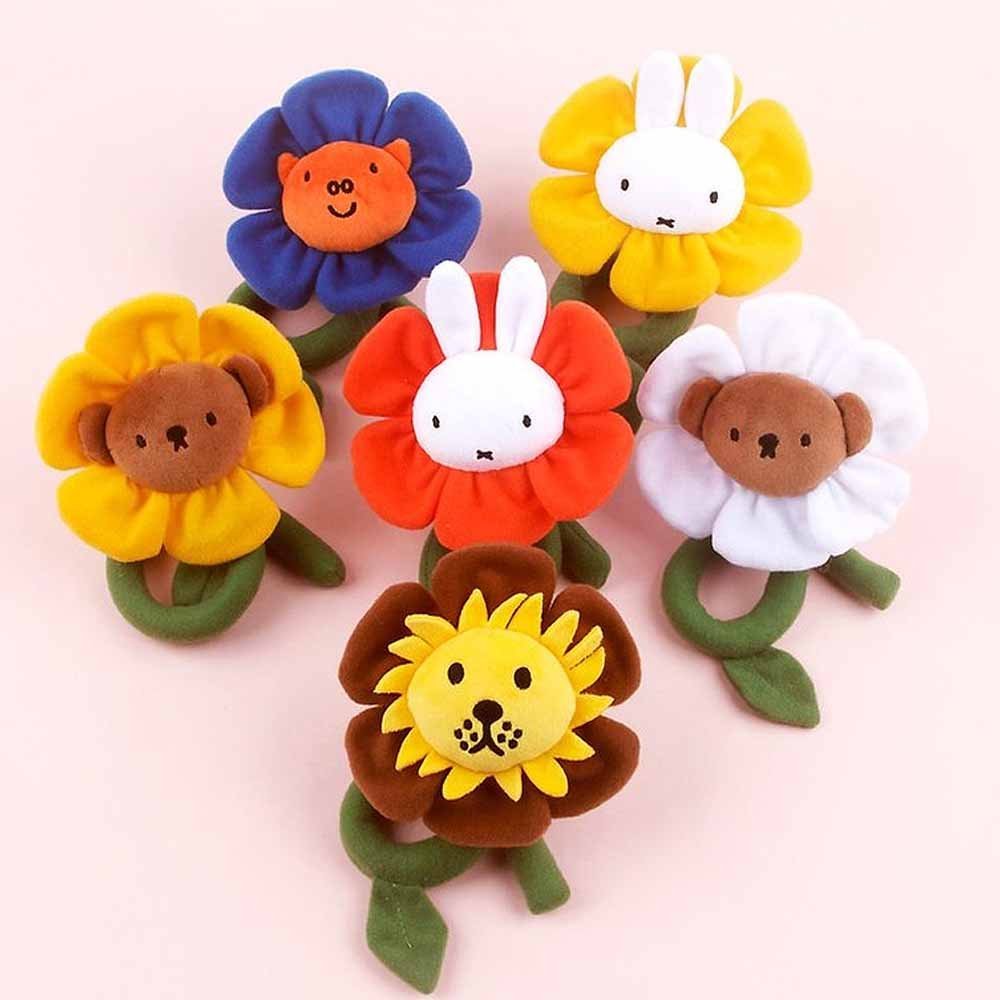 A collection of Miffy and friends Flower Plush stuffed animals in various colors, each designed to look like a flower with animal faces in the center.