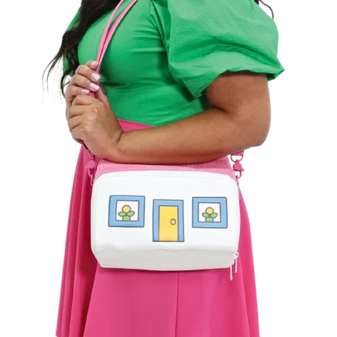 Person wearing a Miffy House-shaped cross-body bag, shown against a white background. The bag is constructed with corduroy on the top section and PU leather on the bottom section, featuring a house design.