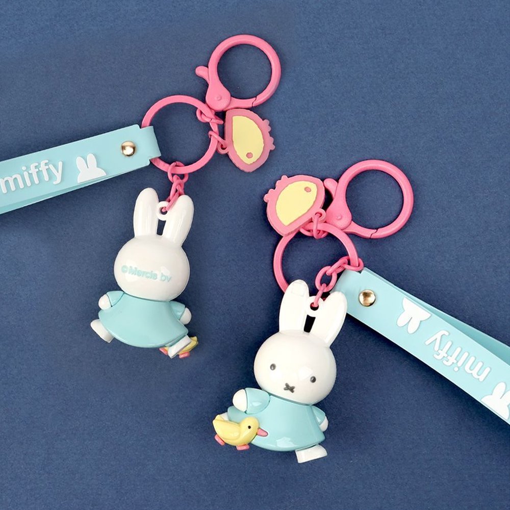 Three Miffy character keychains in pastel blue and pink, featuring 3D Miffy figures with matching silicone wrist straps and lobster clasps.
