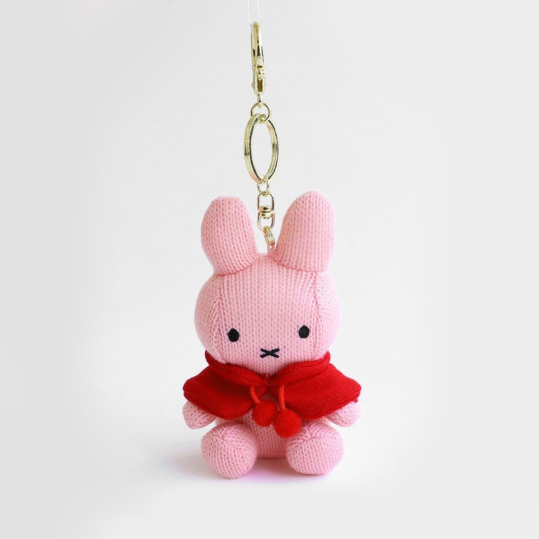 Officially licensed by Miffy pink knit Plush keychain in a red cape on a white background. She's perfect for ornament , displaying, bag decoration or gifting Christmas to Miffy fans of all ages.