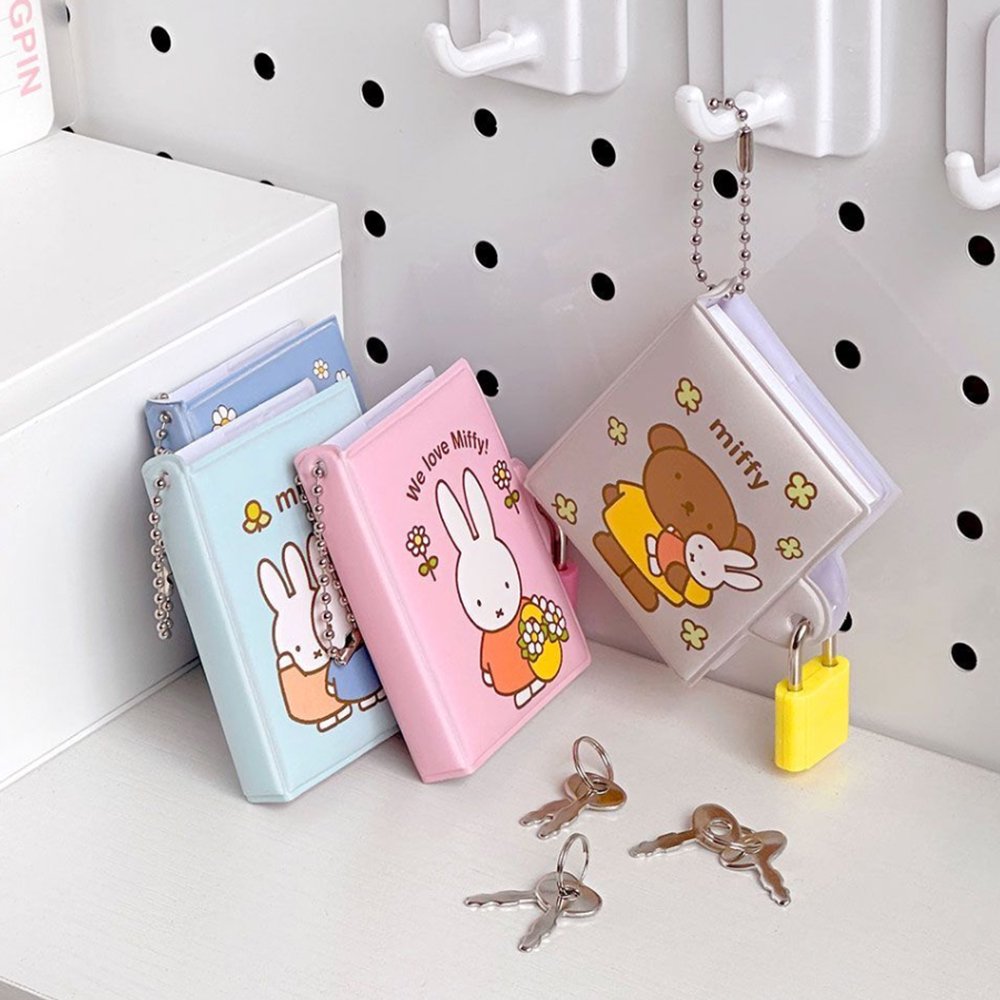 An officially licensed collection of Miffy secret mini notebooks in soft pink, light blue, blue, and grey. Each notebook features a padded cover with Miffy or Boris Bear illustrations, a silver ball chain, and a color-coordinated miniature padlock with keys.