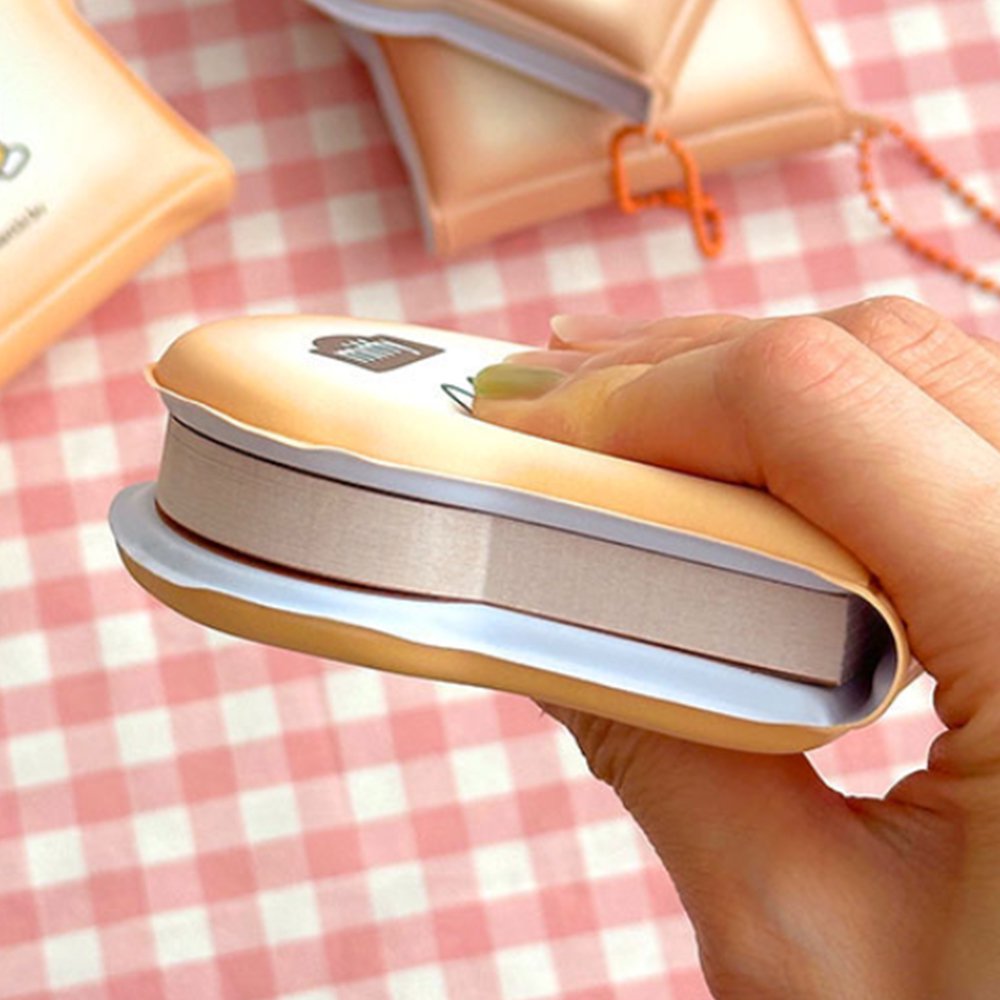 Officially licensed Miffy memo pads shaped like slices of toast. The pads feature a soft tan cover with character illustrations and include orange ball chains.