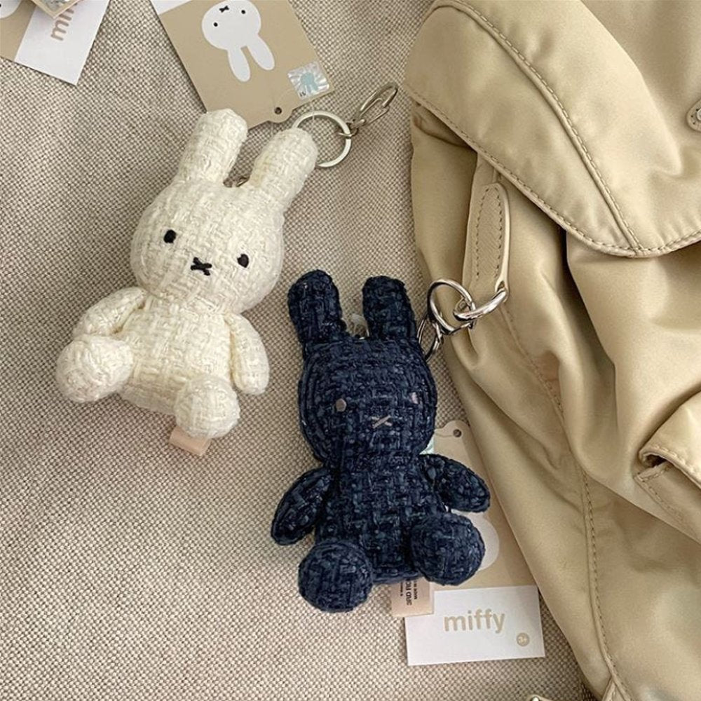 Four officially licensed Miffy textured tweed plush keychains lined up in pink, sage green, cream, and navy blue with attached silver keyrings