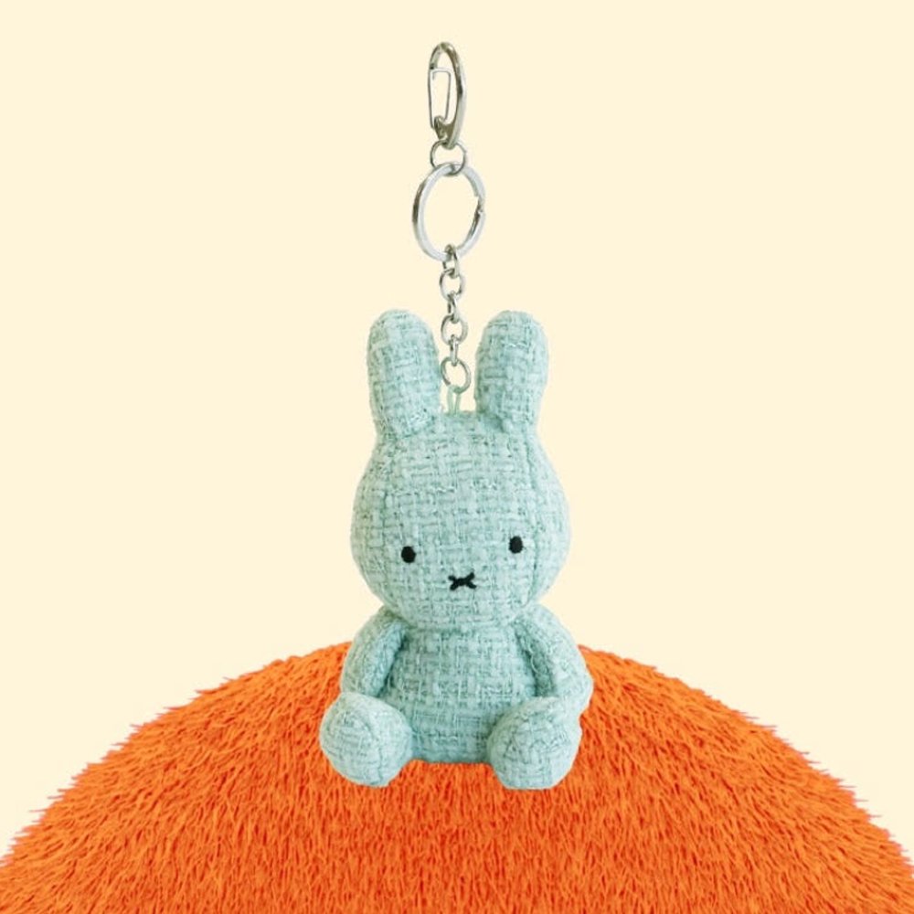 Four officially licensed Miffy textured tweed plush keychains lined up in pink, sage green, cream, and navy blue with attached silver keyrings