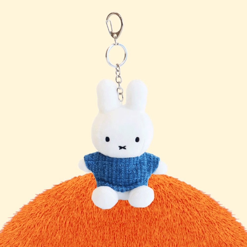 Four officially licensed Miffy plush keychains wearing knit sweaters in orange, green, light blue, and dark blue standing together. Each plush includes an attached silver chain with a lobster clasp at the top.