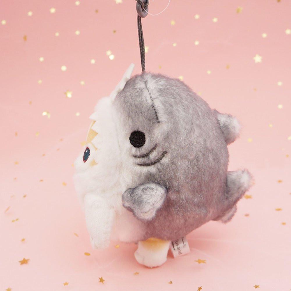 An officially licensed Mofusand shark cat plush keychain featuring a fluffy cream tabby kitten wearing a gray shark onesie with embroidered details