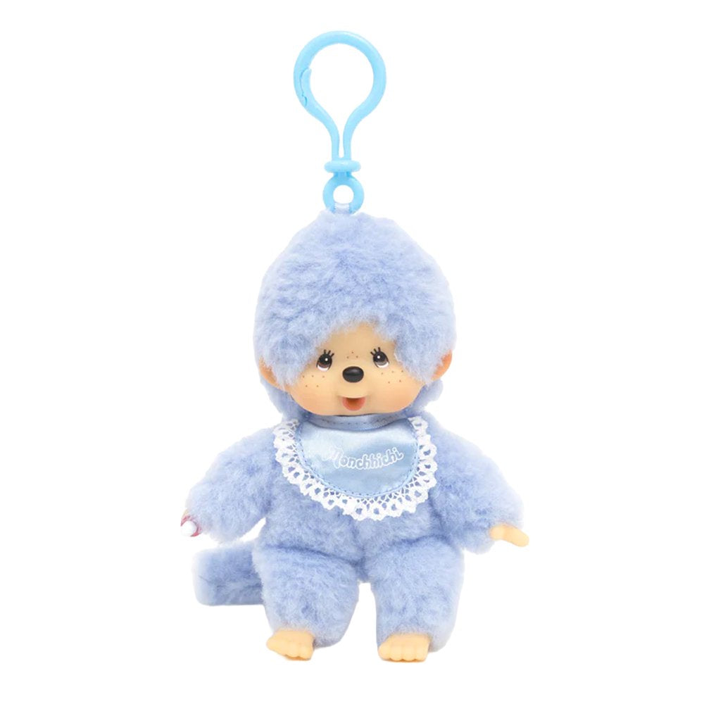 Officially licensed Monchhichi plush keychain doll featuring soft pastel blue fur and a matching light blue plastic clip attached to its head. The doll has a freckled vinyl face and wears a shiny blue satin bib with a white lace border reading "Monchhichi".
