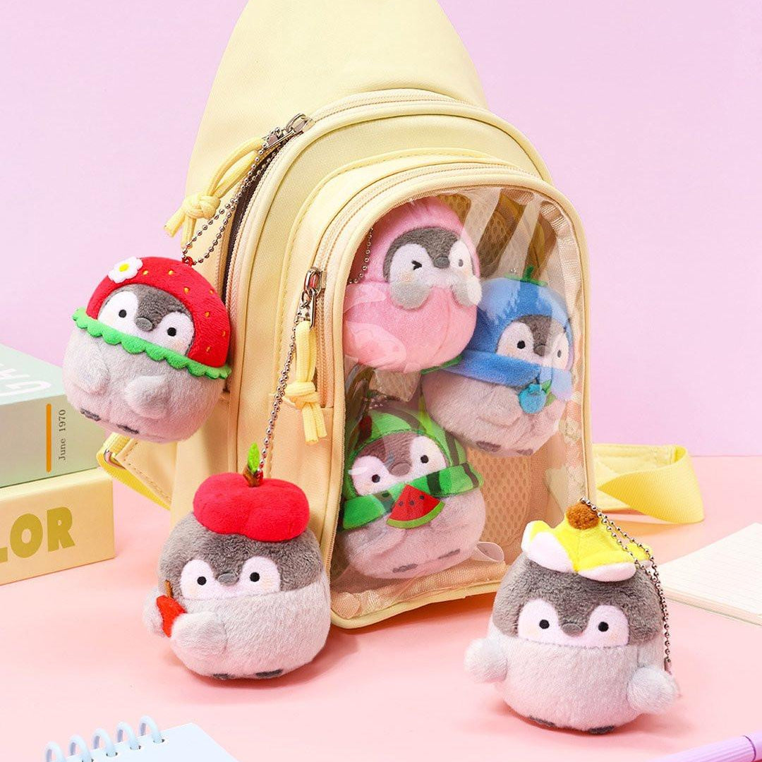 Official Spiralcute Koupen Chan fruit mascot keychains styled in a yellow Ita-bag (clear window backpack). This visual demonstrates a creative way to display your collection on backpacks or school bags, perfect for Y2K aesthetic and "Bag Decorating" enthusiasts.