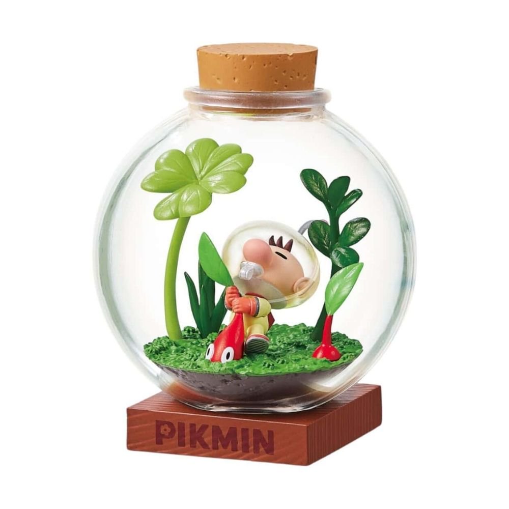 Officially licensed Re-Ment Pikmin Terrarium Collection Figure #1 featuring Captain Olimar and two Red Pikmin. They are standing inside a clear round glass bottle with a cork stopper, placed on a grassy miniature diorama base with clover plants and tall leaves.