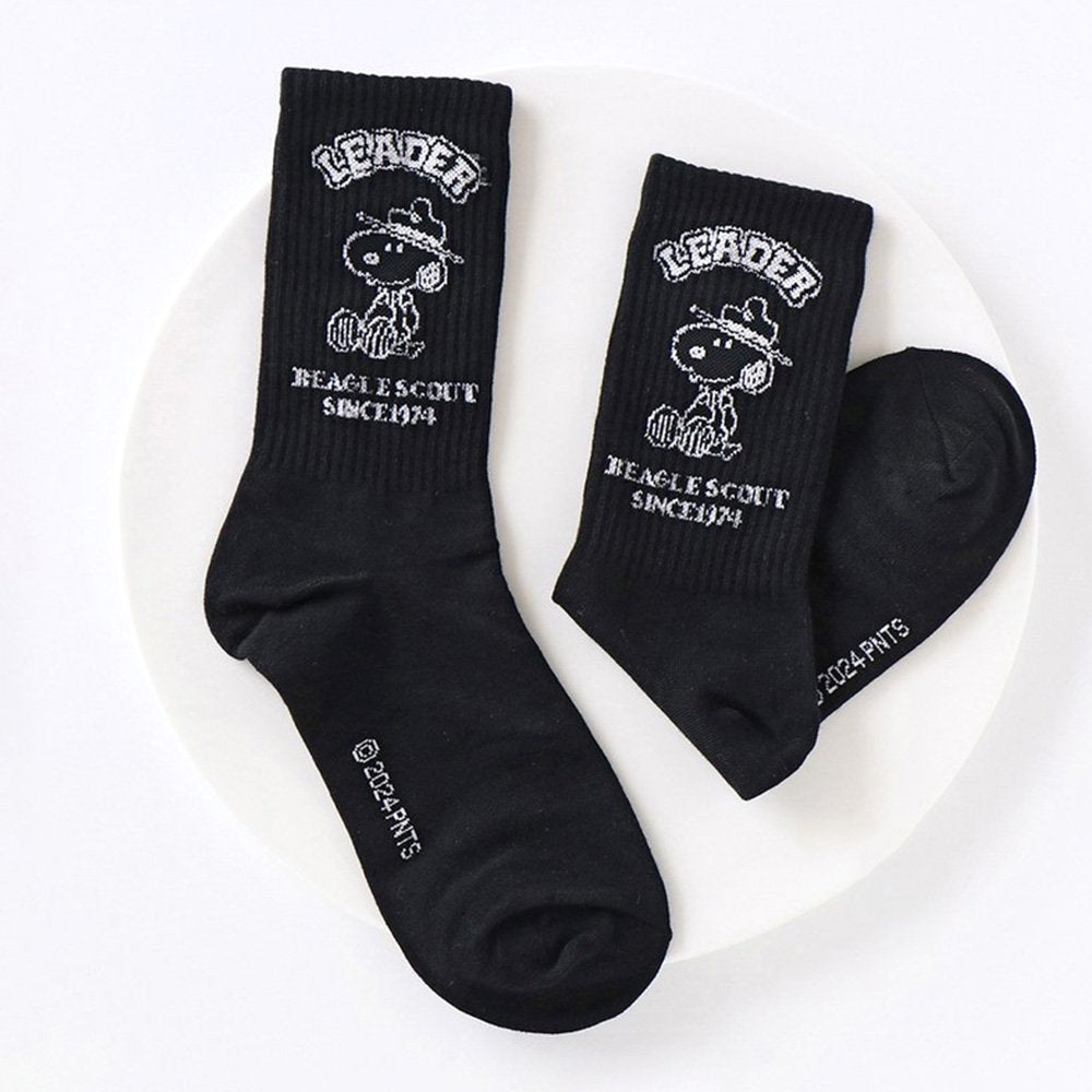 A set of five crew-length socks in black, beige, white, green, and mustard yellow. Each sock features an embroidered graphic of Snoopy as a Beagle Scout leader.