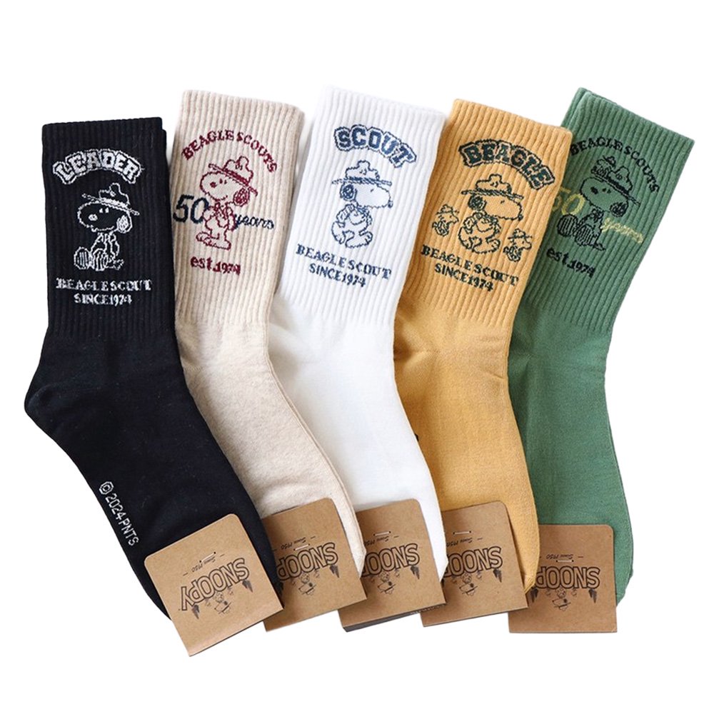 A set of five crew-length socks in black, beige, white, green, and mustard yellow. Each sock features an embroidered graphic of Snoopy as a Beagle Scout leader.