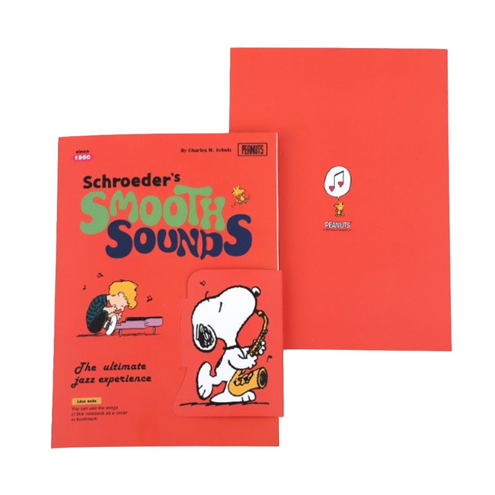 Two officially licensed Peanuts notebooks in red and blue featuring Snoopy and Charlie Brown. The image demonstrates the unique "wing" cover flaps being used as bookmarks and page markers within the lined journal pages.