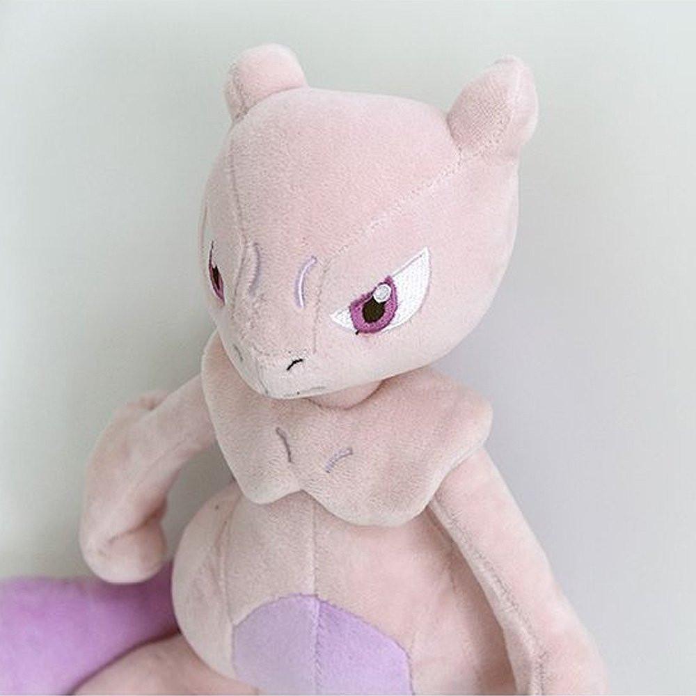 A soft plush toy of the Pokémon Mewtwo, featuring its light purple body, darker purple belly, and long tail, standing upright on a white background