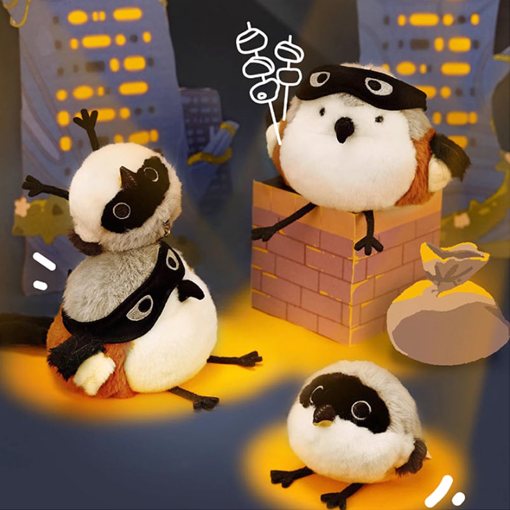 A round, fluffy Long-tailed Shrike bird plush keychain with white and grey fur, a distinct black face mask, and long black legs