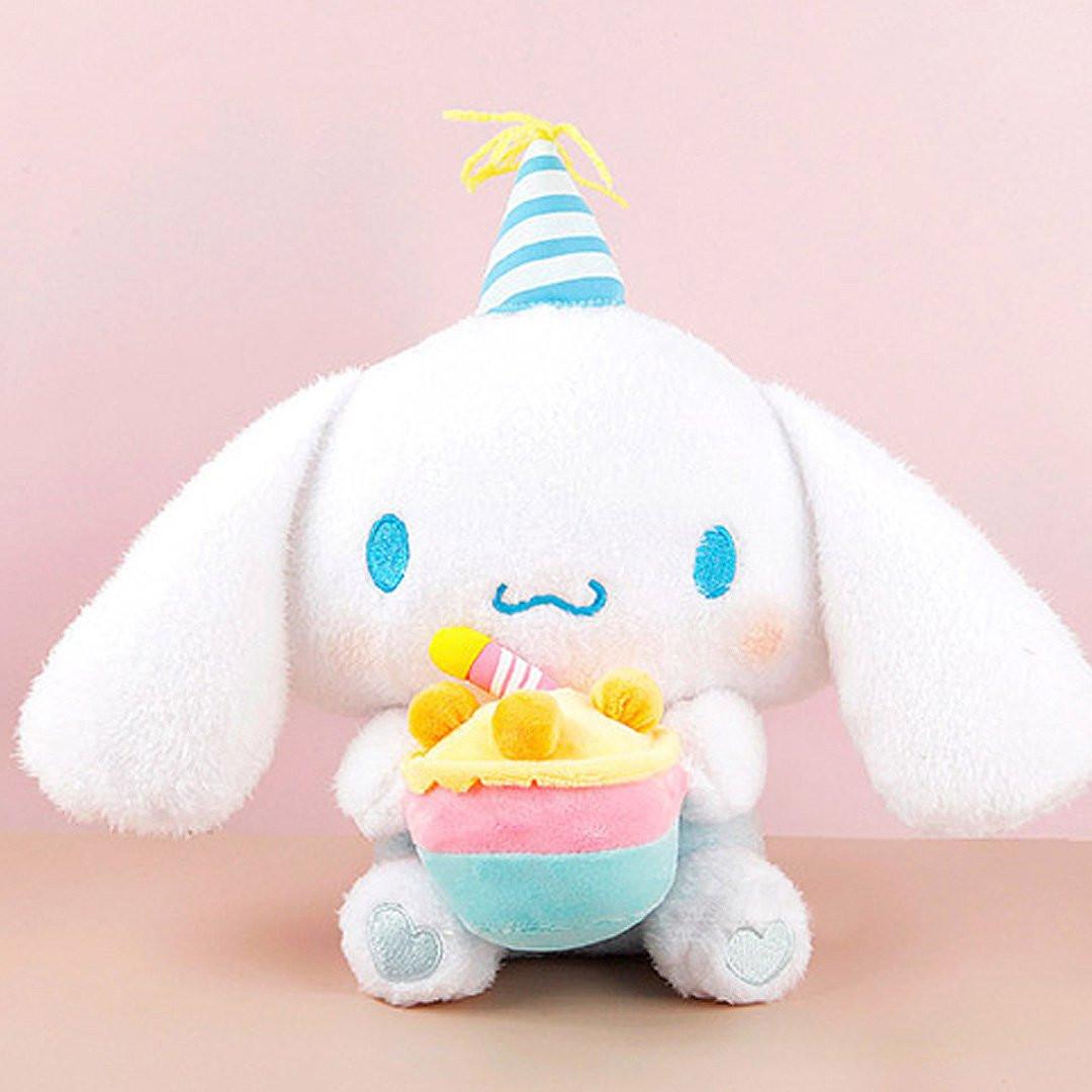 Officially licensed Sanrio Cinnamoroll plush, wearing a charming white party hat topped with a bright yellow tassel, and holding a cake for celebrating a special day.