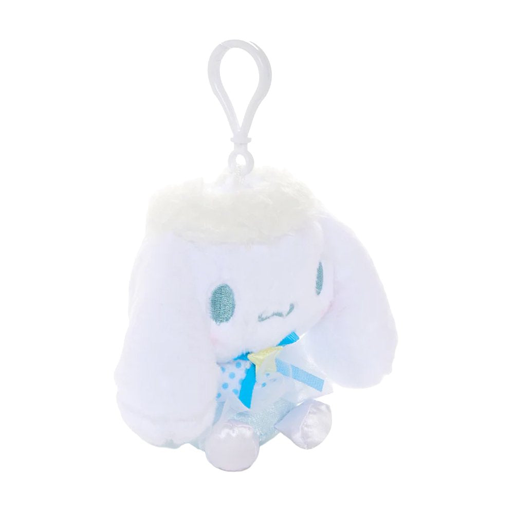 An officially licensed Sanrio Cinnamoroll plush keychain featuring the character in a blue ballerina tutu and polka-dot bodice with a yellow star detail. The plush includes fluffy white head trim, angel wings, and a white plastic clip for easy attachment.