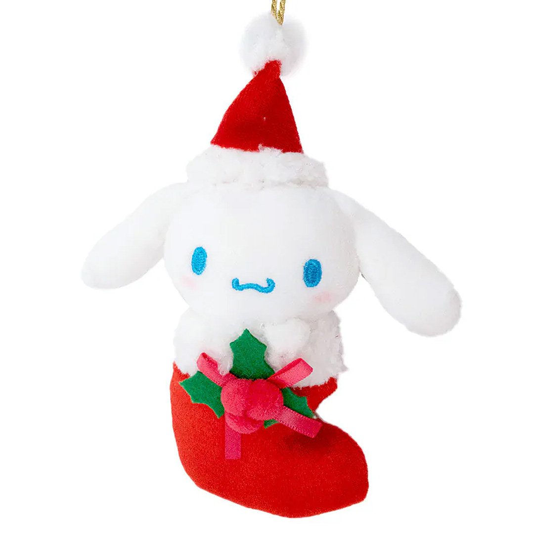 Sanrio Cinnamoroll is dressed for the season wearing a red Santa hat with a white pom-pom while sporting his signature red bow. He sits snugly in a red Christmas stocking adorned with green holly leaves and a decorative ribbon. Crafted from soft plush material, this ornament has a cozy, huggable feel. The attached gold cord loop makes it easy to hang on your Christmas tree.
