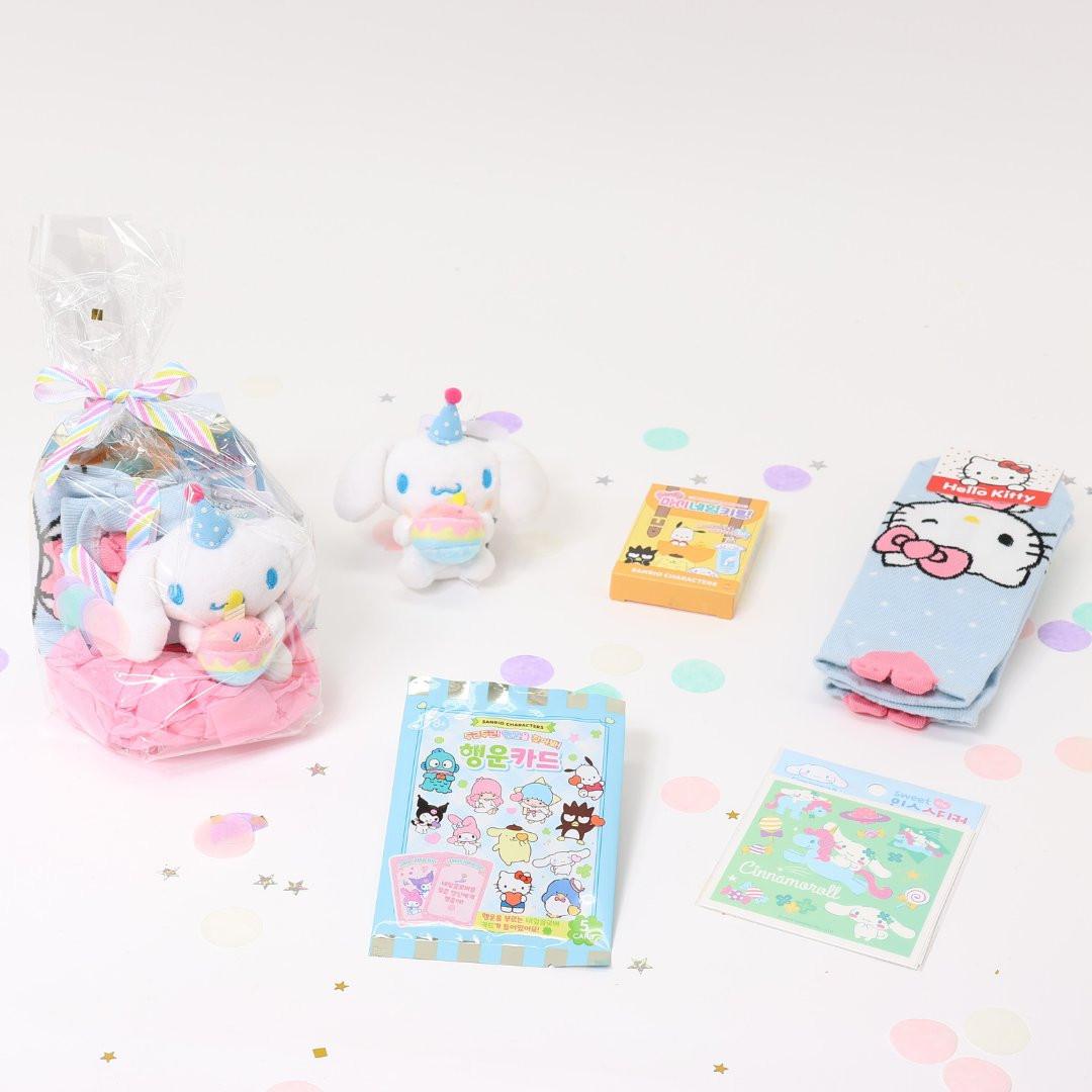 A collection of Sanrio Cinnamoroll Happy Birthday themed gift sets, each containing various colorful items such as plush keychains and socks, all packaged in clear gift bags with pink ribbons.