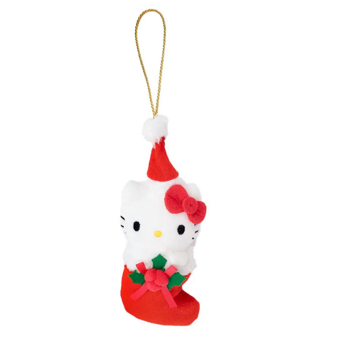 Sanrio Hello Kitty is dressed for the season wearing a red Santa hat with a white pom-pom while sporting his signature red bow. She sits snugly in a red Christmas stocking adorned with green holly leaves and a decorative ribbon. Crafted from soft plush material, this ornament has a cozy, huggable feel. The attached gold cord loop makes it easy to hang on your Christmas tree.