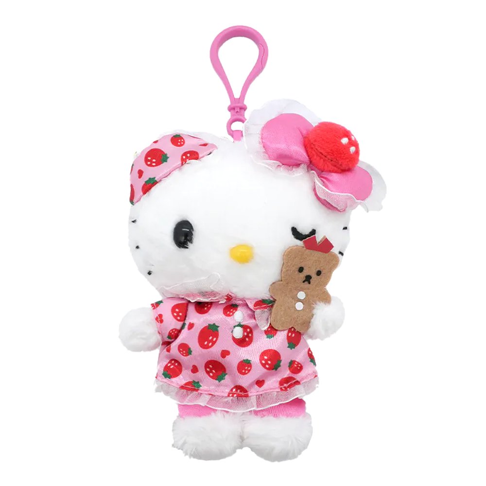 An officially licensed Hello Kitty plush keychain featuring Hello Kitty in a pink strawberry-patterned nightwear dress and a matching sleep mask, holding a small brown teddy bear.