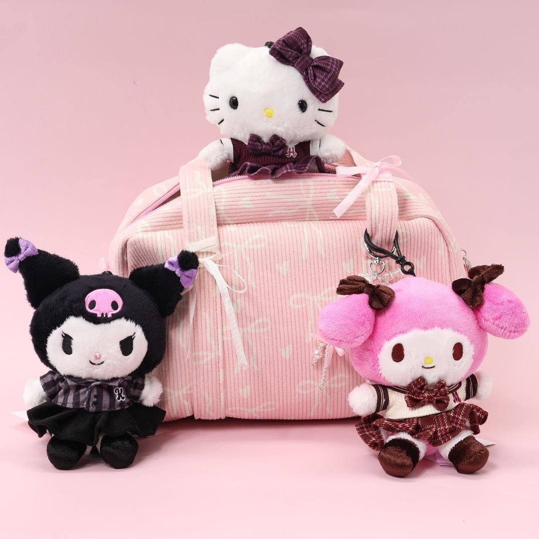 A highly collectible Sanrio plush doll set featuring three characters: Hello Kitty, My Melody, and Kuromi. All are wearing matching school uniform outfits (maroon plaid and black plaid). They are posed around a pink, corduroy duffel bag or carry bag with a bow pattern, making a complete collectible set.