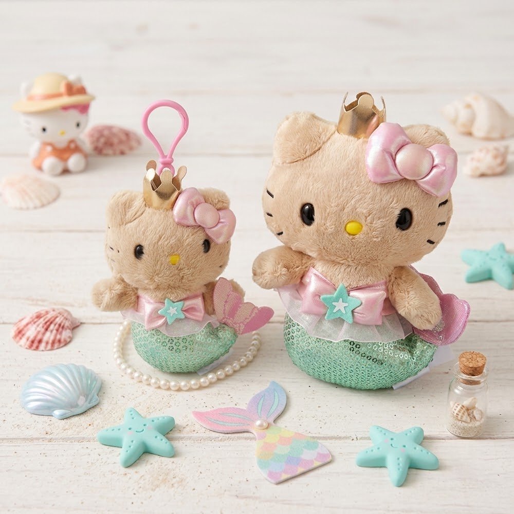 An officially licensed Sanrio Collection of Hello Kitty mermaid plush toy and plush keychain wearing a gold crown, a pink bow, and a green sequined mermaid tail with a starfish embellishment.