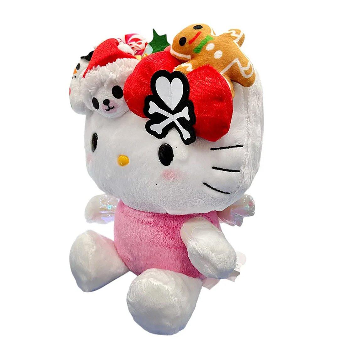 This exclusive Hello Kitty x Tokidoki collaboration is perfect for the holiday season. Her oversized head opens to reveal a collection of mini plush toys including a snowman with red and green buttons, a white polar bear in a red Santa hat, a festive gingerbread man with icing details, green holly leaves with red berries and candy cane. Hello Kitty herself features the signature Tokidoki heart and crossbones skull bow accent in her iconic red bow, along with soft pink cheeks and iridescent holographic wings