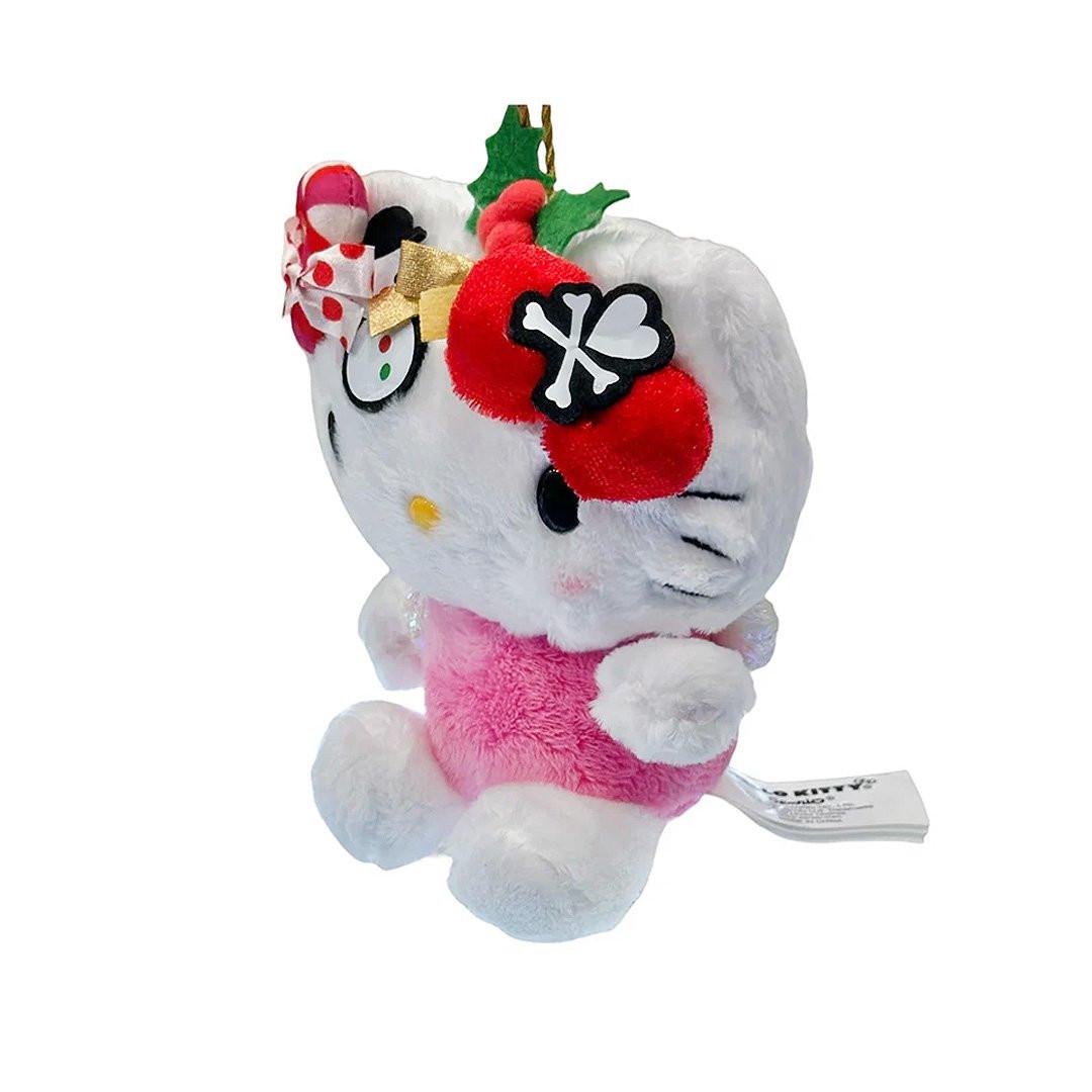 This exclusive Hello Kitty x Tokidoki collaboration is perfect for the holiday season. Her head opens to reveal a collection of mini plush toys including a snowman with red and green buttons, green holly leaves with red berries and candy cane. Hello Kitty herself features the signature Tokidoki heart and crossbones skull bow accent in her iconic red bow, along with soft pink cheeks and iridescent holographic wings on back.