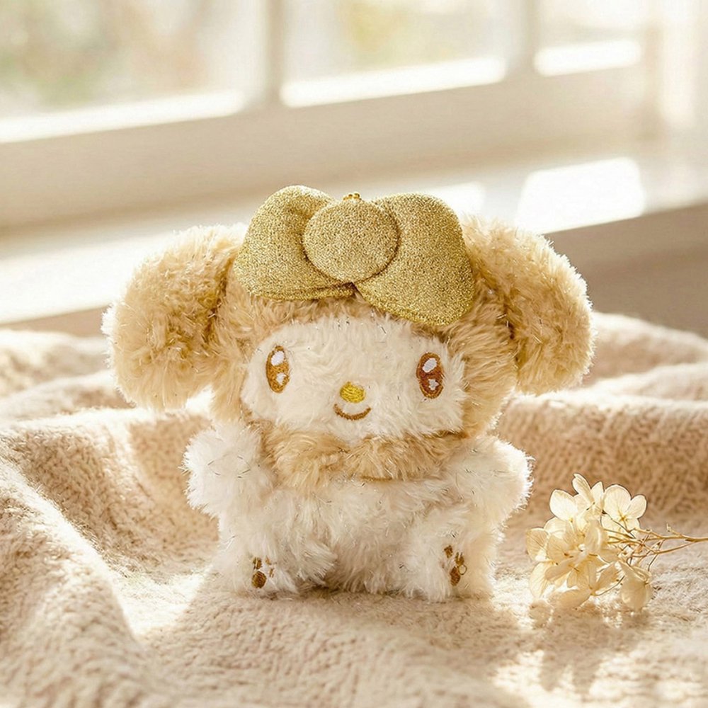 An officially licensed Sanrio My Melody plush keychain featuring a sparkling gold and cream color scheme and a large glittery gold bow.