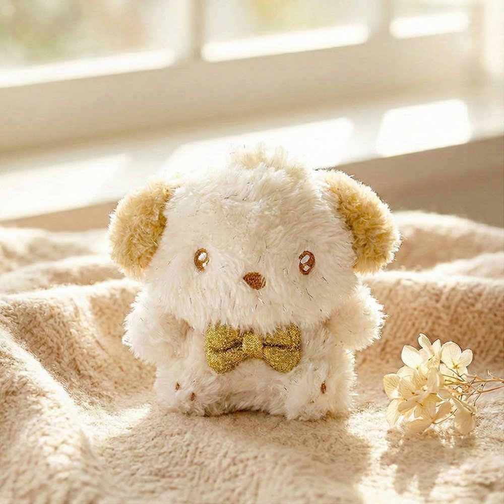 An officially licensed Sanrio Pochacco plush keychain featuring sparkling cream-colored fur, golden-tan ears, and a metallic gold bow tie
