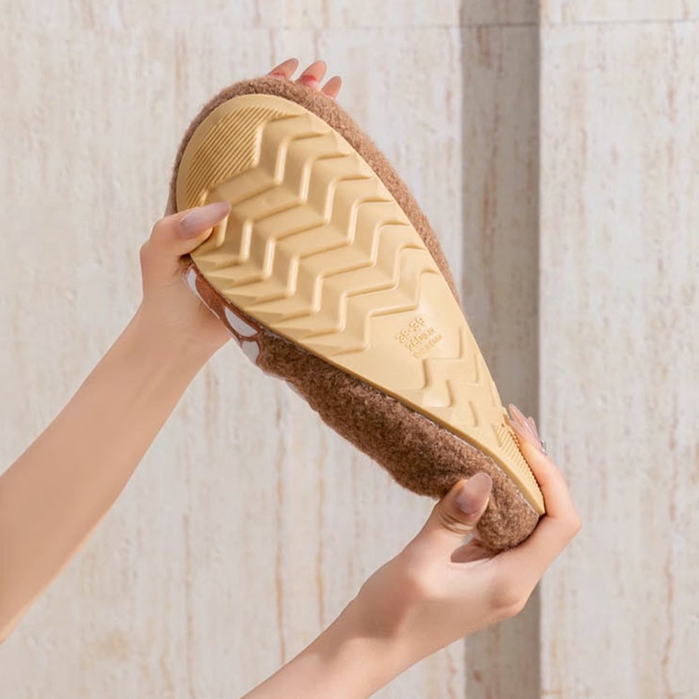 Features an officially licensed Sanrio sherpa fleece Sanrio slippers demonstrating a flexible, tan rubber anti-slip sole.