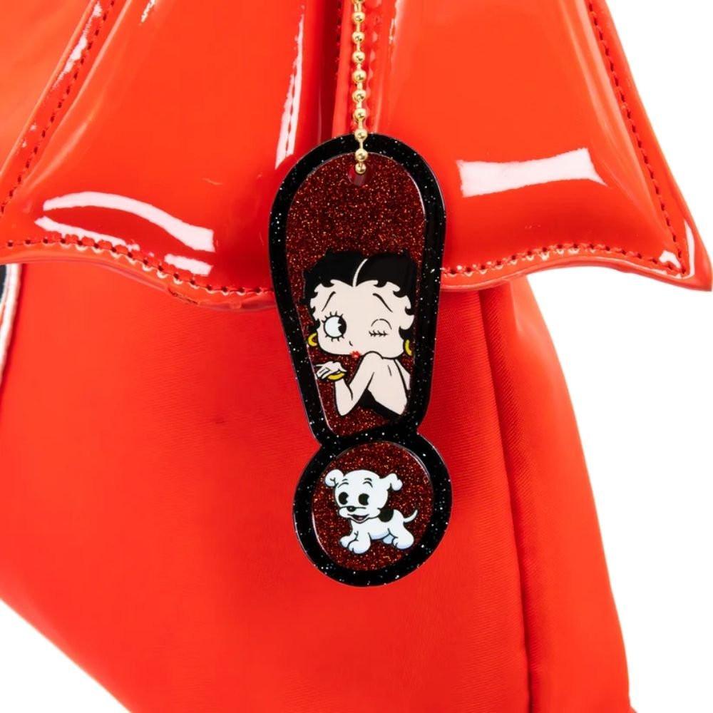 A vibrant red Betty Boop shoulder bag featuring a glossy patent red bow, heart appliqués, and iconic character graphics of Betty Boop and red lips, with a slim over-the-shoulder strap.
