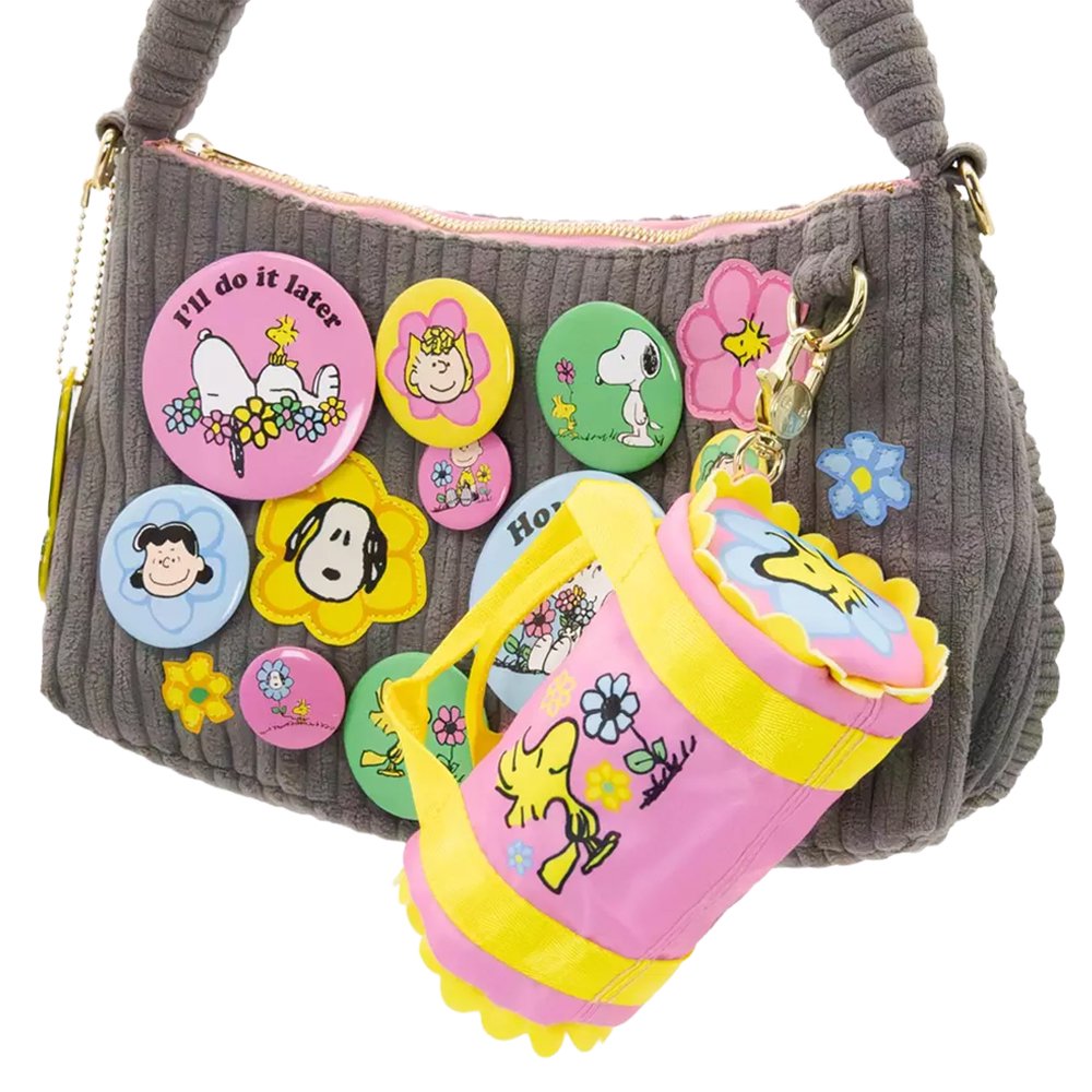 Six miniature duffle-shaped Peanuts character coin pouches in assorted bright pastel colors and floral patterns showcasing characters like Snoopy holding flowers, Woodstock, Lucy, and Charlie Brown