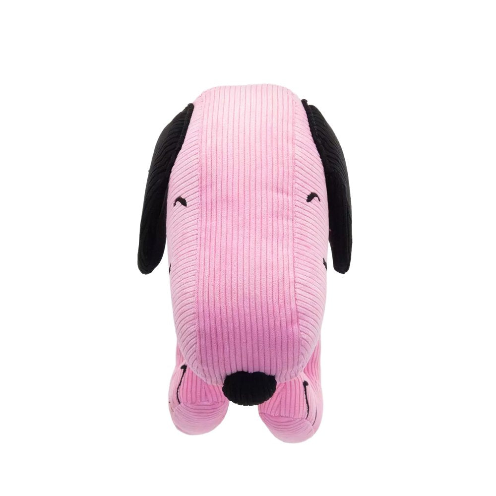 A pink corduroy plush bag shaped like Snoopy with floppy black ears, featuring a small top handle, a detachable pink shoulder strap, and a colorful yellow and blue "PEANUTS" patch on the side