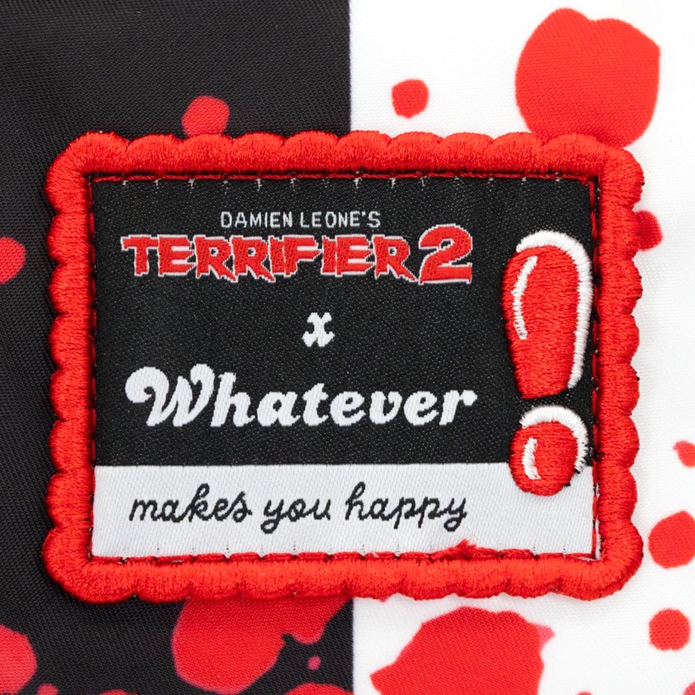 Reversible and convertible horror movie Terrifier 2 tote bag showcasing a split black-and-white design with red blood splatters, a bloody meat cleaver bag charm, and an Art the Clown charm