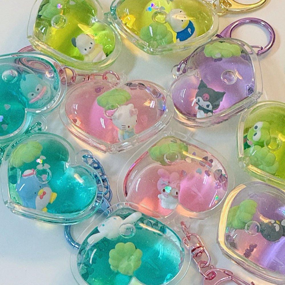 Colorful Sanrio keychains with small figurines inside transparent cases on a white background