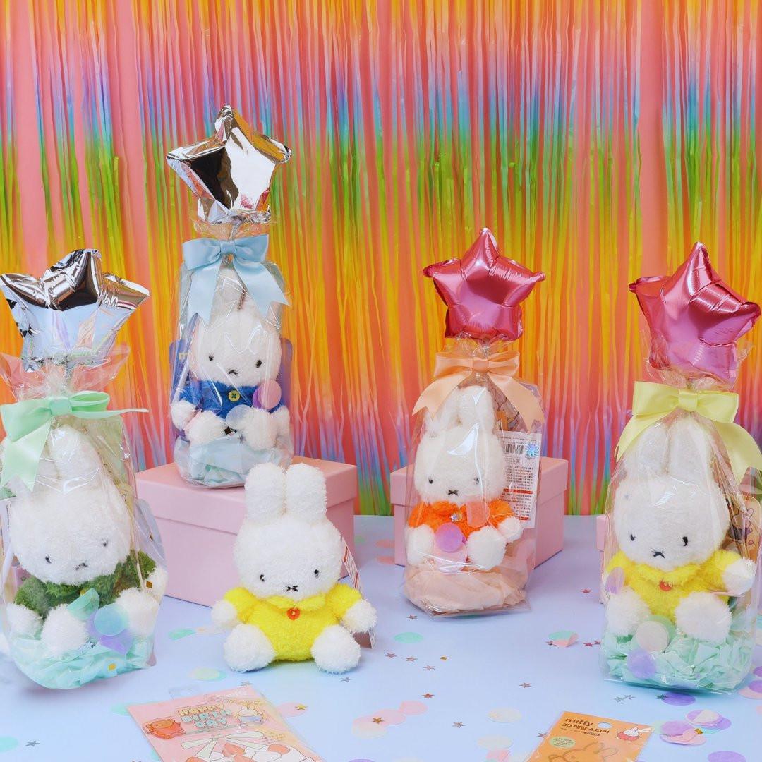 A collection of Miffy-themed birthday gifts including plush keychains, mini notebooks, metal deco stickers, a cake topper, and a letter set, all packaged with a 'Happy Birthday' theme.