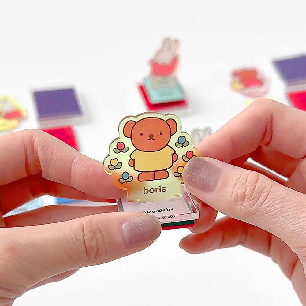 Colorful Miffy friend Boris -shaped stamp held by a person with a white background