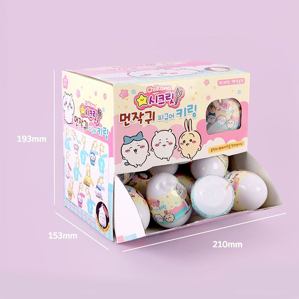 Box of small round toys with cartoon characters on a light purple background