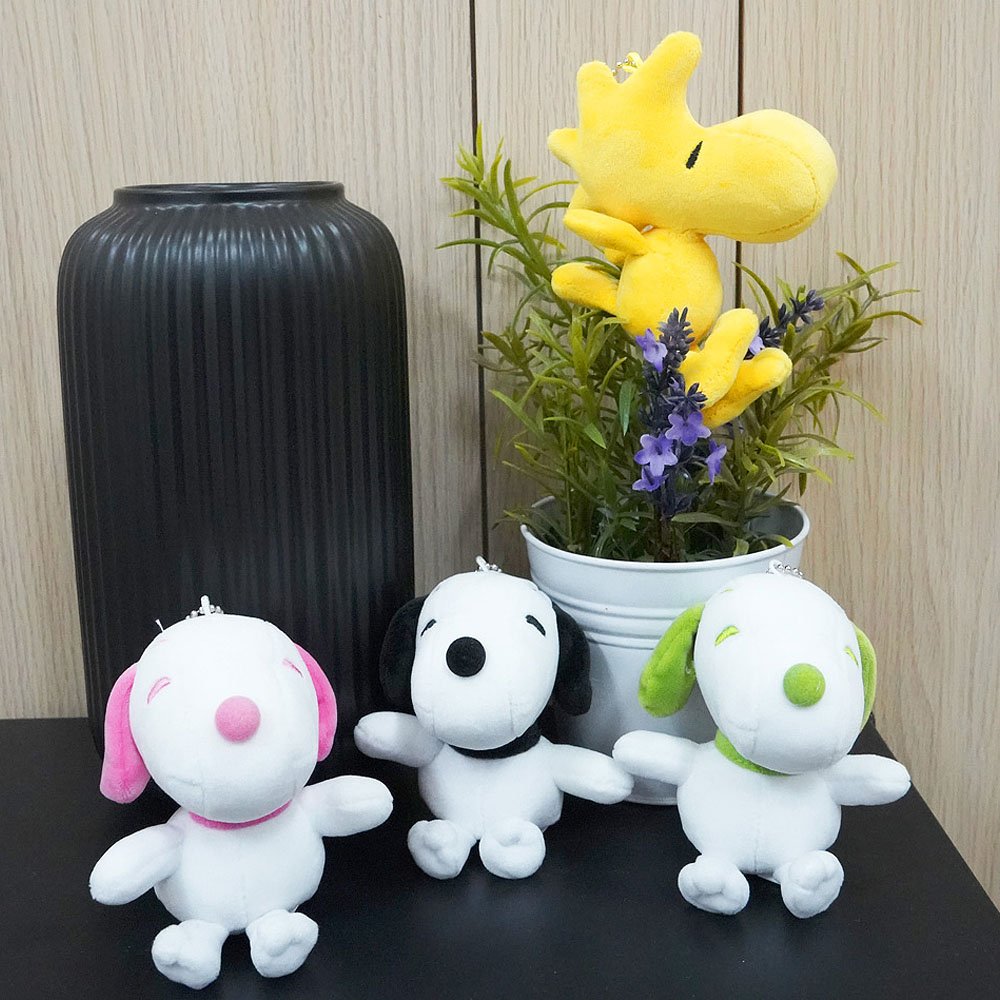 Colorful Peanuts Snoopy plush toys in pink, green, and black displayed together