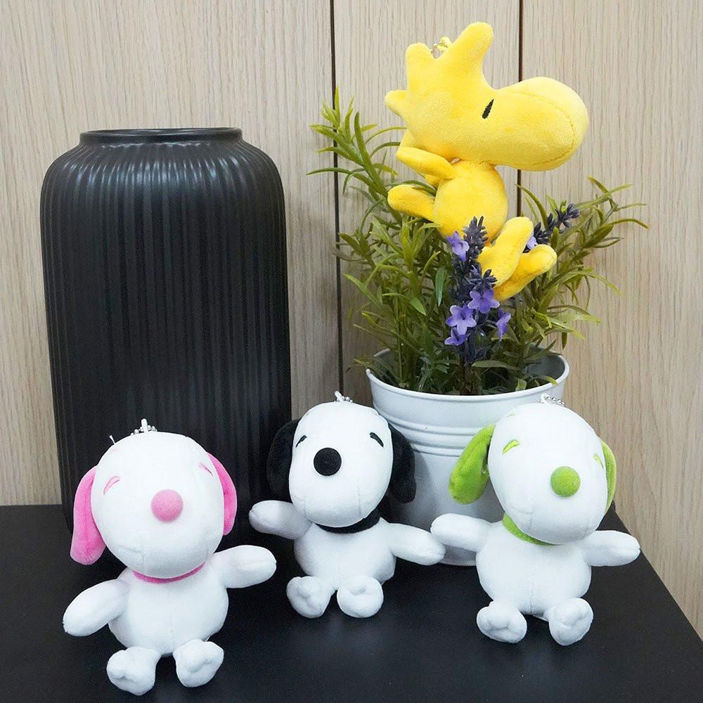 Colorful Peanuts Snoopy plush toys in pink, green, and black displayed together